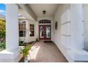 Inviting home entrance with double doors, sidelight windows, brick flooring, and charming decorative accents at 821 Shallow Brook Ave, Winter Springs, FL 32708