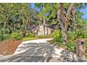 View of a long driveway leading to a well-maintained brick house surrounded by mature trees at 828 Timber Court Ct, Apopka, FL 32712