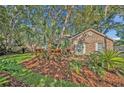 Well-maintained front yard with lush green grass, mature landscaping, and a brick facade at 828 Timber Court Ct, Apopka, FL 32712