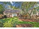 Charming brick home featuring a well-manicured lawn and lush tropical landscaping at 828 Timber Court Ct, Apopka, FL 32712