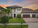 A beautiful home with a lush front lawn and an attached three-car garage at sunset at 8491 Pippen Dr, Orlando, FL 32836