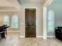 Beautiful foyer featuring dark wood door, tile flooring, and bright windows with white plantation shutters at 8491 Pippen Dr, Orlando, FL 32836