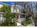 Attractive two-story house displays a welcoming porch, verdant shrubbery, and mature tree canopies at 9141 Camden Gardens St, Orlando, FL 32827