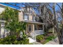 Charming two-story home featuring a cozy front porch, classic shutters, and lush landscaping at 9141 Camden Gardens St, Orlando, FL 32827