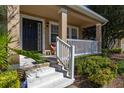 Cozy front porch with white railing leads to a home's entrance framed by manicured greenery at 9141 Camden Gardens St, Orlando, FL 32827