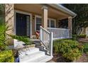 Inviting front porch with seating and view of lush landscaping leading to the black front door at 9141 Camden Gardens St, Orlando, FL 32827