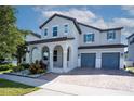 Charming two-story home with a brick driveway, archway covered porch, and a two-car garage at 9845 Emerald Berry Dr, Winter Garden, FL 34787