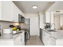Bright kitchen features sleek white cabinets, stainless steel appliances, and elegant gray countertops at 1031 S Hiawassee Rd # 2517, Orlando, FL 32835