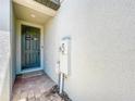 Covered front door with 'Welcome' sign and brick entrance, with white textured walls at 1045 Desert Candle Dr, Ocoee, FL 34761