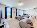 Living room featuring a gray sectional sofa, neutral walls, and a view of the backyard at 1045 Desert Candle Dr, Ocoee, FL 34761