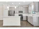 Modern kitchen featuring stainless steel appliances, gray cabinets, and a center island at 11258 Whistling Pine Way, Orlando, FL 32832