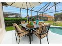 Outdoor dining area with table and chairs, umbrella and view of pool and screened patio at 117 Rosso Dr, Davenport, FL 33837