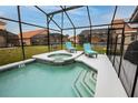 A close up of a screened-in pool and hot tub area with lounge chairs at 117 Rosso Dr, Davenport, FL 33837