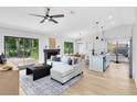Bright, open-concept living area with a modern fireplace, ceiling fan, and sliding doors to the backyard at 12929 Louisiana Woods Ct, Orlando, FL 32824