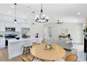 Open-concept kitchen and living area with modern lighting, stainless appliances, and a breakfast bar at 12929 Louisiana Woods Ct, Orlando, FL 32824
