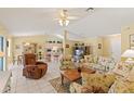 Open-concept living room with tile floors and views of the adjacent dining and kitchen areas at 12952 Downstream Cir, Orlando, FL 32828