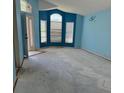 Light blue vacant living room with large windows and view to the front yard at 13543 Emeraldview Dr, Orlando, FL 32828