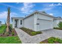 Charming single-story home features a well-manicured lawn, paved driveway, and attached two-car garage at 1459 Santorini Way, Tavares, FL 32778