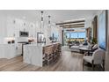 Open-concept kitchen and living area with a large island, modern lighting, and views of the outdoor landscape at 1459 Santorini Way, Tavares, FL 32778