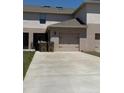 Townhome exterior showcasing a spacious driveway leading to a two-car garage at 1832 Katz Crossing Dr, Kissimmee, FL 34744