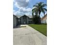 Traditional single story home featuring a large concrete driveway and mature landscaping at 233 Red Maple Dr, Kissimmee, FL 34743