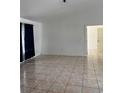 Open living room with neutral paint, tile flooring, and a view into the next room at 233 Red Maple Dr, Kissimmee, FL 34743