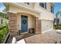 Inviting front entrance with a blue door, stone accents, and a cozy seating area at 266 Caryota Ct, New Smyrna Beach, FL 32168