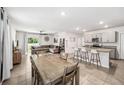 Open-concept living space featuring tile floors, a dining area, and a kitchen with bar seating at 266 Caryota Ct, New Smyrna Beach, FL 32168