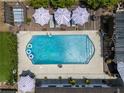 Aerial view of a sparkling pool surrounded by a deck, lounge chairs and patio umbrellas at 2801 Plaza Terrace Dr, Orlando, FL 32803