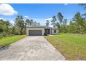 Beautiful single-story home featuring a two-car garage and a long driveway with landscaped front yard at 3072 Sw 168Th Loop, Ocala, FL 34473