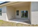 A covered patio area with a concrete floor, window and sliding glass door, perfect for outdoor relaxation at 3072 Sw 168Th Loop, Ocala, FL 34473