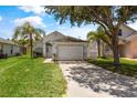 Classic single-Gathering home boasting a two-car garage and well-maintained lawn, showcasing suburban charm at 3078 Mandolin Dr, Kissimmee, FL 34744