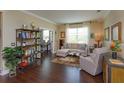Cozy living room with hardwood floors, neutral paint, plenty of natural light and an open doorway to an office at 3755 Sanibel St, Clermont, FL 34711