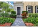 Home showcasing a welcoming front entrance with a black door, well-manicured landscaping and a brick border at 4001 Corrine Dr, Orlando, FL 32814