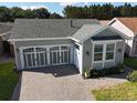 An aerial view of a well-maintained single-Gathering home with a two-car garage and landscaped surroundings at 406 Alcove Dr, Groveland, FL 34736