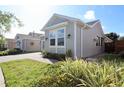 Well-kept gray home showing tidy landscaping and a brick driveway to the right side at 406 Alcove Dr, Groveland, FL 34736