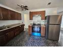 Kitchen features updated appliances, brown cabinets, granite countertops, and modern ceiling fan at 4061 Kirkland Blvd, Orlando, FL 32811
