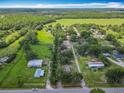 Expansive aerial view showcasing the property's surroundings with trees, and blue skies above at 4432 Freedom Rd, Kissimmee, FL 34746