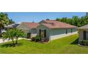 Well-maintained home with lush green lawn, mature landscaping, and a glimpse of the side entrance at 7233 Mystic Brook Way, Davenport, FL 33896