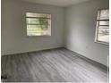 A bright bedroom is shown with modern gray flooring and two large windows at 7604 Forest City Rd # 11, Orlando, FL 32810
