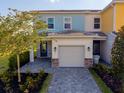 A charming townhome with a paved driveway leading to an attached garage, complemented by manicured landscaping at 772 Driving Range Ct, Kissimmee, FL 34747