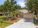 Lovely single-story home with a driveway, front lawn and mature trees at 778 Del Prado Dr, Kissimmee, FL 34758