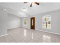 Bright living room featuring neutral paint, tile floors, and natural light from dual windows at 778 Del Prado Dr, Kissimmee, FL 34758