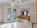 Elegant foyer with marble floors, decorative glass double doors, and an open view to the living room at 8333 Via Verona, Orlando, FL 32836