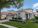 Beautiful home featuring a manicured lawn, red front door, brick driveway, and a two-car garage at 8333 Via Verona, Orlando, FL 32836