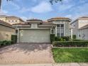 Home featuring a brick driveway, two-car garage, manicured lawn, and a well-maintained exterior at 8333 Via Verona, Orlando, FL 32836