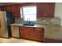 Kitchen with granite counters, stylish backsplash, and modern stainless steel appliances at 8613 Edge O Woods Ct, Orlando, FL 32819
