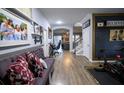 Inviting hallway with wood floors, wall decor, and a purple bench leading to the home's living spaces and staircase at 9208 Chandler Dr, Groveland, FL 34736