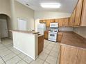 Functional kitchen with wood cabinetry, modern appliances, and a convenient breakfast bar at 928 Chanler Dr, Haines City, FL 33844