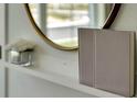 Close up of shelf with book and round mirror adding to the modern design at 950 Princess Sabal Pt, Haines City, FL 33844